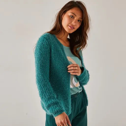 Un cardigan scurt pentru o siluetă minionă, confecționat dintr-un material pufos tricotat.